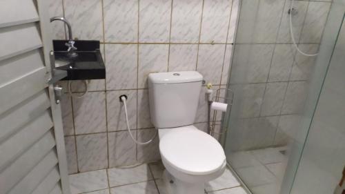 a small bathroom with a toilet and a shower at Casa com piscina no coração de Lucena in Lucena