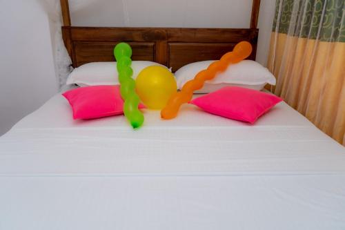 a toy person on a bed with two pillows at Rainforest Holiday Inn in Deniyaya