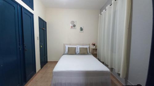 sypialnia z dużym białym łóżkiem w pokoju w obiekcie Suíte em Hospedaria no Centro Histórico w mieście Ouro Preto