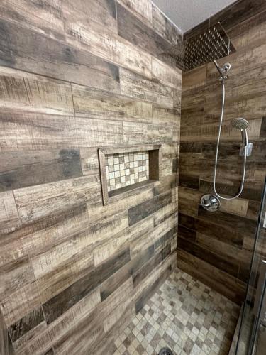 uma casa de banho com chuveiro e paredes de madeira em Zen Space @ Harker Heights em Harker Heights