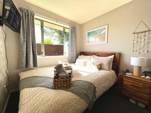 a bedroom with a bed with a basket on it at Golden Pearl in Christchurch