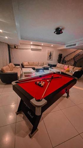 a pool table in the middle of a living room at درة العروس فيلا البيلسان الشاطي الازرق in Durat  Alarous