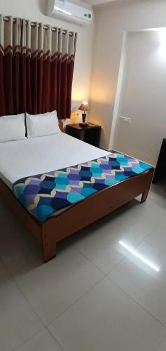 a large bed in a room with at Global Mansion Service Apartment in Bangalore
