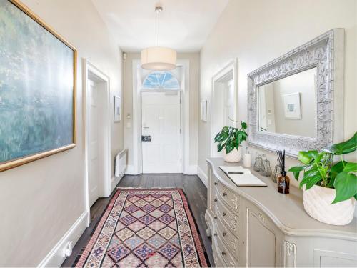 a bathroom with a vanity with a mirror and a rug at The Red Feather Inn in Launceston