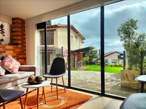 a living room with a large glass window at Hermoso apartamento con vista al lago in Paipa