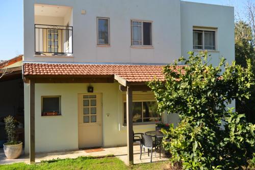 a house with a porch and a table in front of it at Rothschild Galilee Hospitality in Hagoshrim