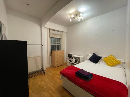 a bedroom with a bed with a red blanket at London Cozy & Spacious Room 2 mins away from Train Station in London