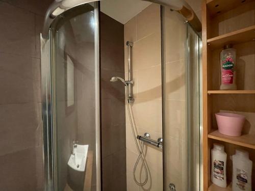 a shower with a glass door in a bathroom at London Cozy & Spacious Room 2 mins away from Train Station in London