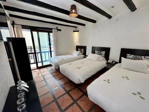 a bedroom with two beds and a balcony at Hatun Inti Classic in Machu Picchu