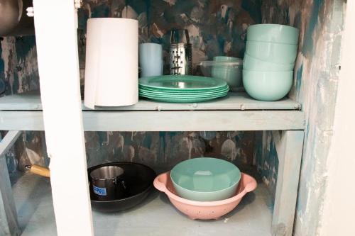 a shelf with bowls and plates on it at Casona Antigua con Jacuzzi a metros de la Basílica de Luján in Luján
