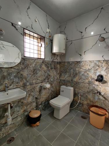 La salle de bains est pourvue de toilettes et d'un lavabo. dans l'établissement SV Serviced Apartments, à Chikmagalur