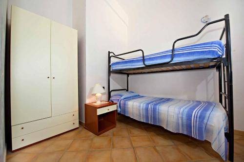 a bedroom with a bunk bed and a table with a lamp at Blunda Holiday Home in Castellammare del Golfo