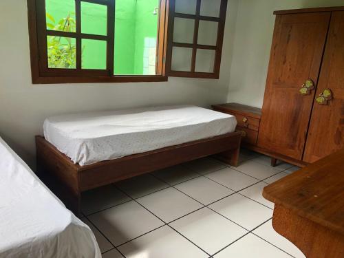 1 dormitorio con cama y ventana. en Refúgio Beira Mar, en Santa Cruz Cabrália