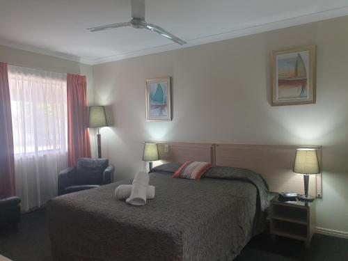 a bedroom with a bed with a stuffed animal on it at Cobar Central Motor Inn in Cobar