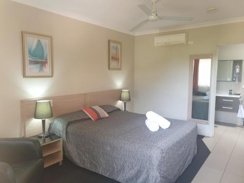 a bedroom with a bed and a chair in it at Cobar Central Motor Inn in Cobar