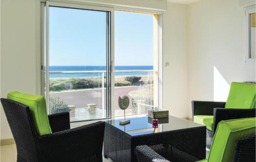 ein Wohnzimmer mit einem Tisch und Stühlen sowie einem großen Fenster in der Unterkunft Lovely Home In Saint-Germain-Sur-Ay in Saint-Germain-sur-Ay