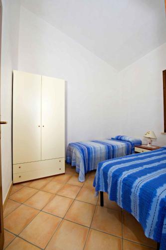 a bedroom with two beds and a white cabinet at Blunda Holiday Home in Castellammare del Golfo