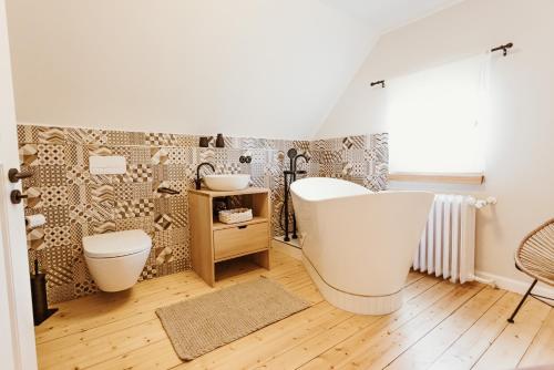 een badkamer met een wit bad en een toilet bij Waldchalet Am Steinberg FEWO in Wernigerode