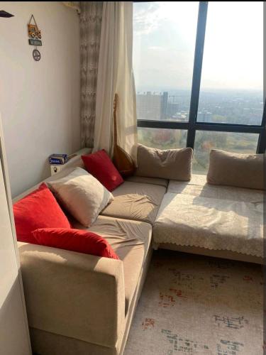 um sofá num quarto com uma grande janela em Üniversite kapısında köy manzaralı daire 