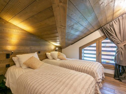 deux lits dans une chambre avec un plafond en bois dans l'établissement Appartement de Standing en Duplex à Val-d'Isère avec Balcon, Parking et Wifi - FR-1-694-22, à Val dʼIsère