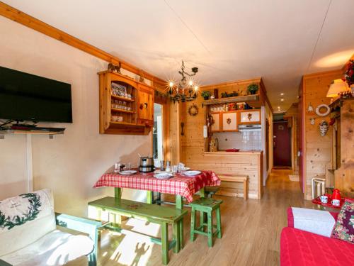 un salon avec une table et une cuisine dans l'établissement Coquet appartement montagnard proche commodités - FR-1-694-35, à Val dʼIsère