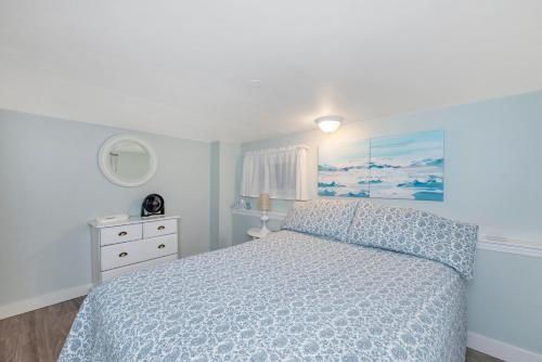 a bedroom with a bed with a blue comforter at Quaint 1 bedroom lower suite in Victoria, BC in Victoria