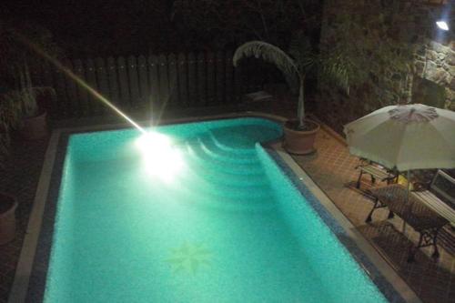 a swimming pool at night with an umbrella at Castello in Valguarnera Caropepe