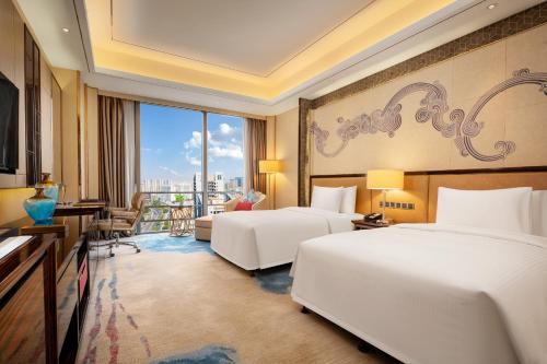 a hotel room with two beds and a balcony at Wanda Vista Dongguan in Dongguan