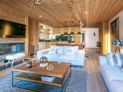 un salon avec un canapé et une table dans l'établissement Luxueux 4 pièces avec balcon, cheminée et services conciergerie à Val-d'Isère - FR-1-694-65, à Val dʼIsère