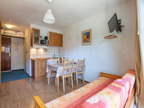 Cette chambre comprend une cuisine et une salle à manger avec une table. dans l'établissement Studio cosy proche des pistes, balcon Sud/Est, navette, local à skis – Val-d'Isère - FR-1-694-86, à Val dʼIsère