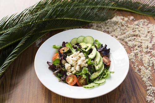 Seymourʼs圣玛丽亚海湾海滩度假村和别墅的桌上放着沙拉的白色盘子