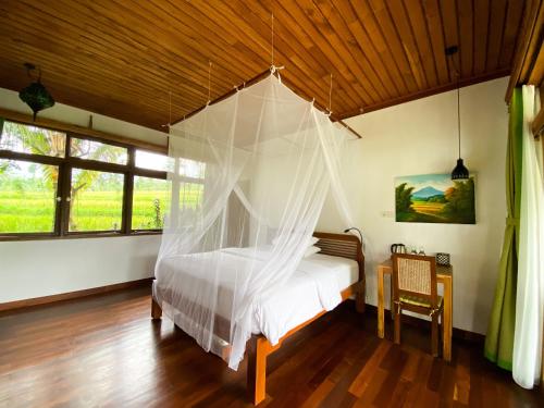a bedroom with a bed with mosquito net at Lesong Hotel and Restaurant in Munduk