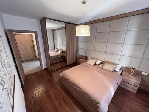 1 dormitorio con 1 cama grande y espejo en White Homes 3 - Master Quart, en Podgorica