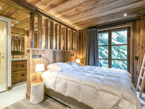 a bedroom with a bed in a room with wooden walls at Appartement Val-d'Isère, 4 pièces, 8 personnes - FR-1-694-102 in Val-d'Isère