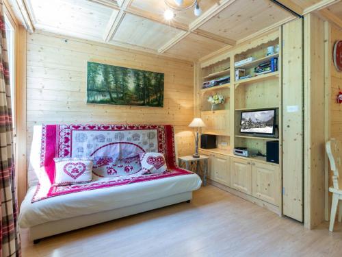 une chambre avec un lit dans une pièce aux murs en bois dans l'établissement Appartement spacieux avec wifi, balcon Sud, parking, proche pistes - Val d'Isère - FR-1-694-112, à Val dʼIsère