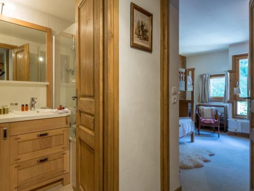 La salle de bains est pourvue d'un lavabo et d'une coiffeuse avec un miroir. dans l'établissement Appartement raffiné à Val-d'Isère, 6 personnes, pied des pistes, WiFi - FR-1-694-116, à Val dʼIsère
