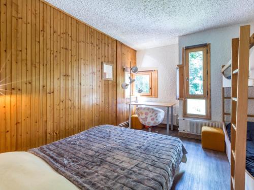 une chambre avec un lit et un mur en bois dans l'établissement Charmant appartement aux pieds des pistes - 3 pièces pour 6 personnes - FR-1-694-111, à Val dʼIsère