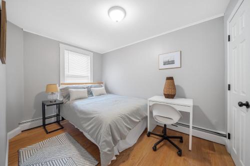 a white bedroom with a bed and a desk at Easy Commute South Boston 4BR 1BH Apt in Boston