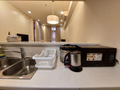 a kitchen counter with a sink and a microwave at Sea Breeze Verandas at Anvaya Cove Penthouse Unit with Complete Sea View in Morong