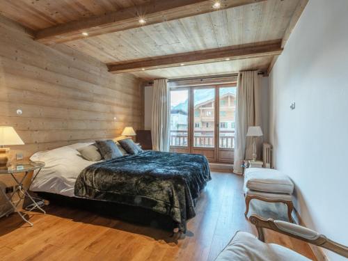 une chambre avec un lit et une grande fenêtre dans l'établissement Luxueux 4 pièces avec alcove, superbe séjour, prestations haut de gamme, au cœur de Val-d'Isère - FR-1-694-167, à Val dʼIsère