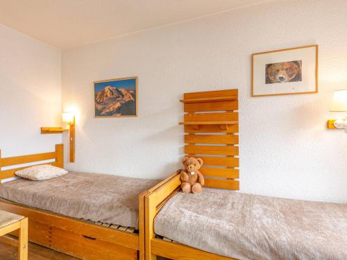 - une chambre avec deux lits et un ours en peluche dans l'établissement Appartement skis aux pieds à La Daille avec balcon et cuisine équipée - FR-1-694-175, à Val dʼIsère