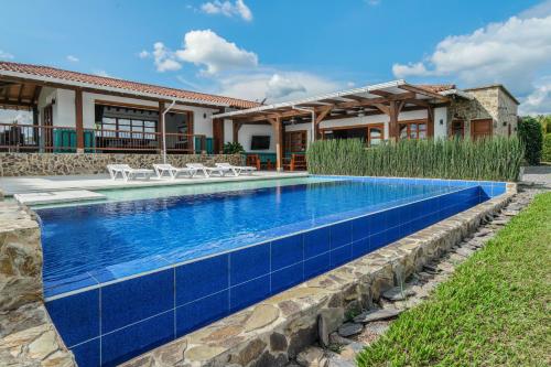 a swimming pool with blue tile in front of a house at San Miguel de Montenegro in Montenegro