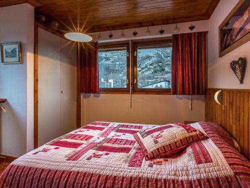 - une chambre avec un lit doté d'une couette rouge et blanche dans l'établissement Appartement spacieux pour 6, proche pistes et centre aquasportif à Val-d'Isère - FR-1-694-194, à Val dʼIsère