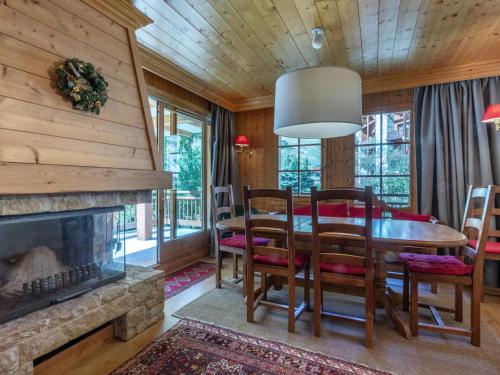 une salle à manger avec une table et des chaises et une cheminée dans l'établissement Appartement standing 3 pièces avec terrasse, cheminée, parking et WiFi à Val-d'Isère - FR-1-694-199, à Val dʼIsère