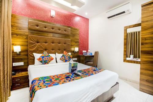 Un dormitorio con una cama grande y una pared roja. en FabHotel Amour - Nr Mumbai International Airport, en Bombay