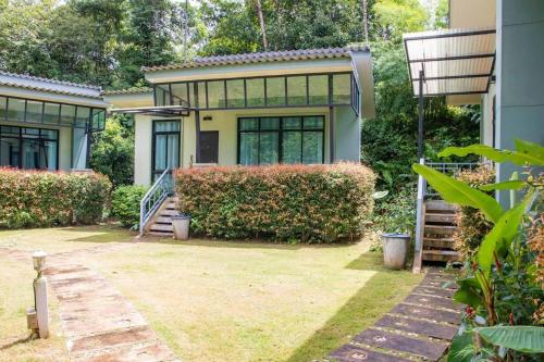 a house with a staircase in front of it at Snapper House in Khao Lak
