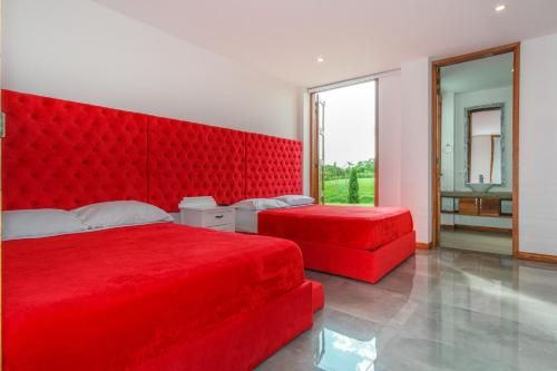 a bedroom with two red beds and a large window at San Miguel de Montenegro in Montenegro