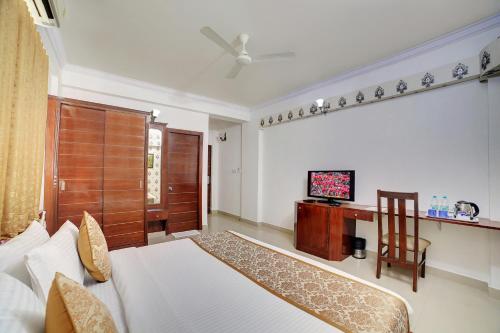 a bedroom with a bed and a television in it at The Liverpool Blue Hotels in Bengaluru