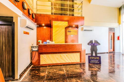 a man in a suit standing in a room at FabHotel Atlas Plaza Andheri East in Mumbai