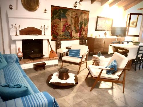 a living room with a couch and chairs and a fireplace at Agrampeli in Limenaria